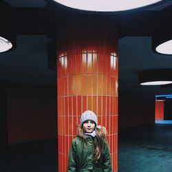 Girl standing by pillar at parking lot