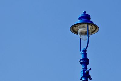 Low angle view of street light against blue sky