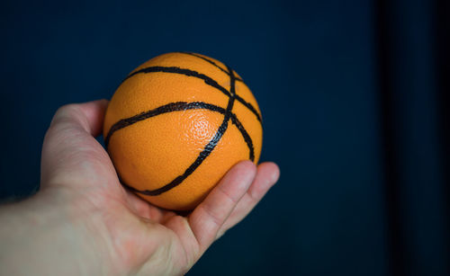 Close-up of hand holding orange