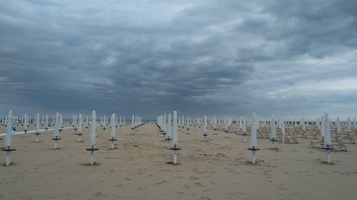 Panoramic view of wooden posts on beach against sky