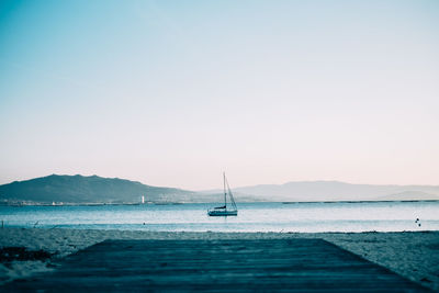 Sailboat sailing in sea at sunset