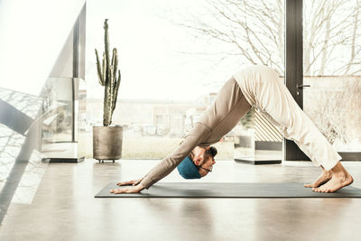 Male yoga teacher practicing downward facing dog pose