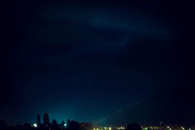 Low angle view of illuminated city against sky at night