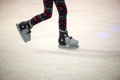 Low section of child skateboarding on ice rink