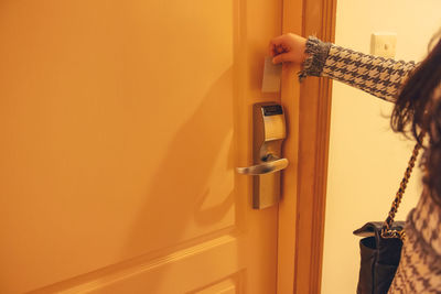 Midsection of woman standing by door at home