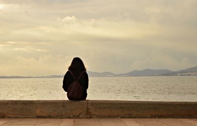 Rear view of woman looking at sea against sky