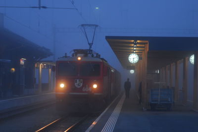 Train on railroad station platform at night