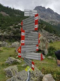 Road sign on cliff against sky