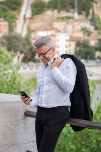 Businessman doing video conference call on smartphone and talking in the street, looking at screen