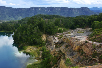 Scenic view of river by mountains against sky