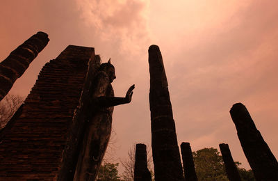 Low angle view of statue against sky at sunset