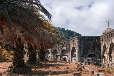 Low angle view of arch bridge against cloudy sky