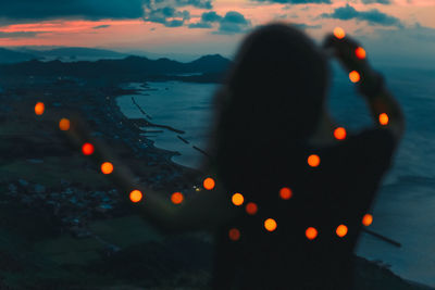 Close-up of silhouette woman at beach during sunset