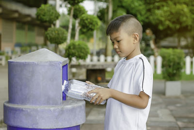 Side view of boy holding umbrella