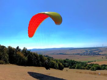 Person paragliding against sky