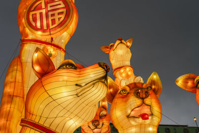 Low angle view of illuminated lanterns against clear sky