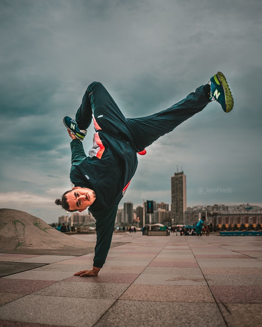 sky, full length, lifestyles, balance, real people, leisure activity, architecture, skill, mid-air, day, one person, built structure, cloud - sky, city, young adult, nature, men, young men, building exterior, outdoors, human arm, leg, breakdancing