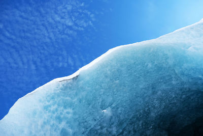 Low angle view of icicles against blue sky