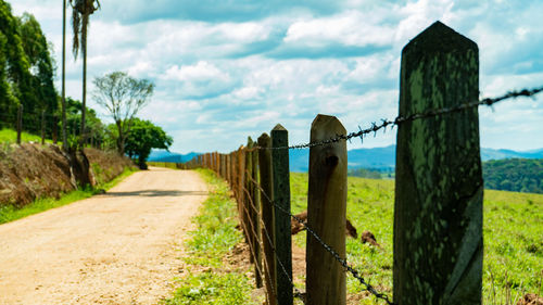 Fence on field against sky