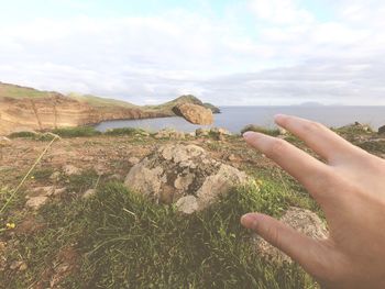 Cropped image of person hand against sky