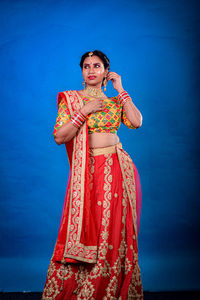 Portrait of young woman standing against wall