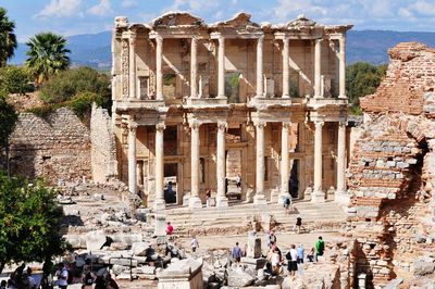 People at celsus library ruins on sunny day