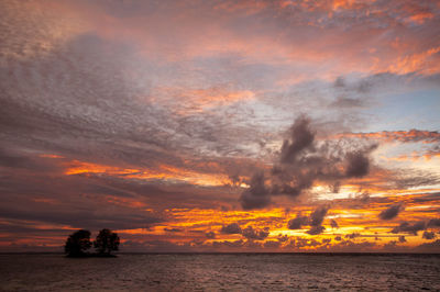 Scenic view of sea against dramatic sky during sunset