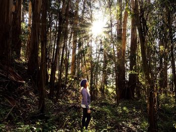 Man standing on tree trunk in forest