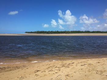 Scenic view of beach against blue sky