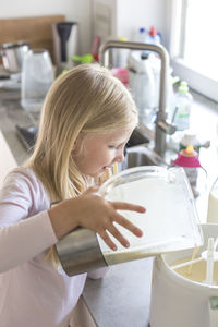 Midsection of woman holding drink at home