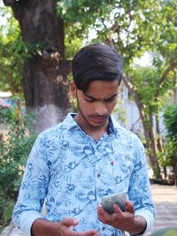 Young man using mobile phone outdoors