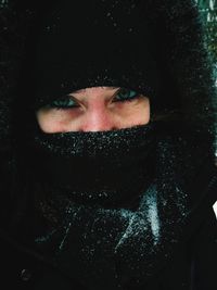 Close-up portrait of woman with snow covered face