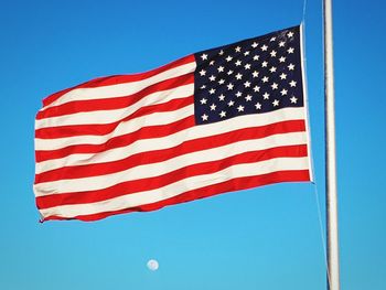 American flag waving against clear blue sky