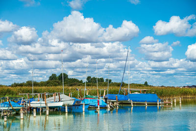 Boats moored in lake against sky