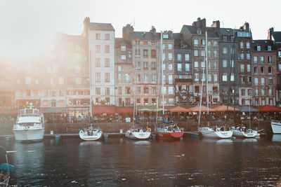 Boats in canal by buildings in city