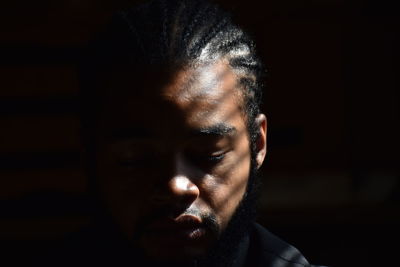 Close-up portrait of young man against black background