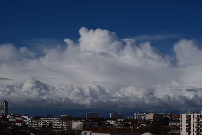 Aerial view of cityscape against blue sky