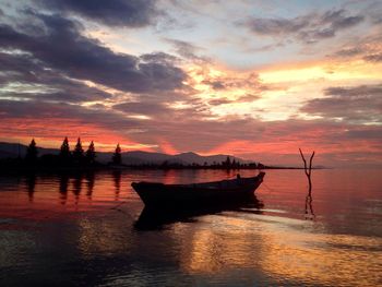 Lone boat in calm sea against scenic sky