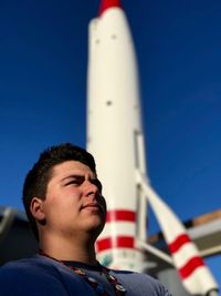 Close-up of man standing against rocket