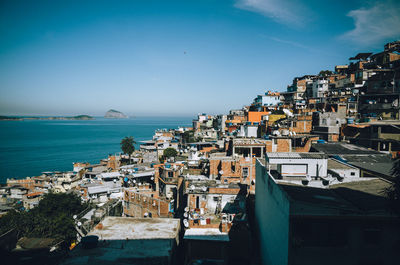 High angle view of brazilian slum by sea against clear sky