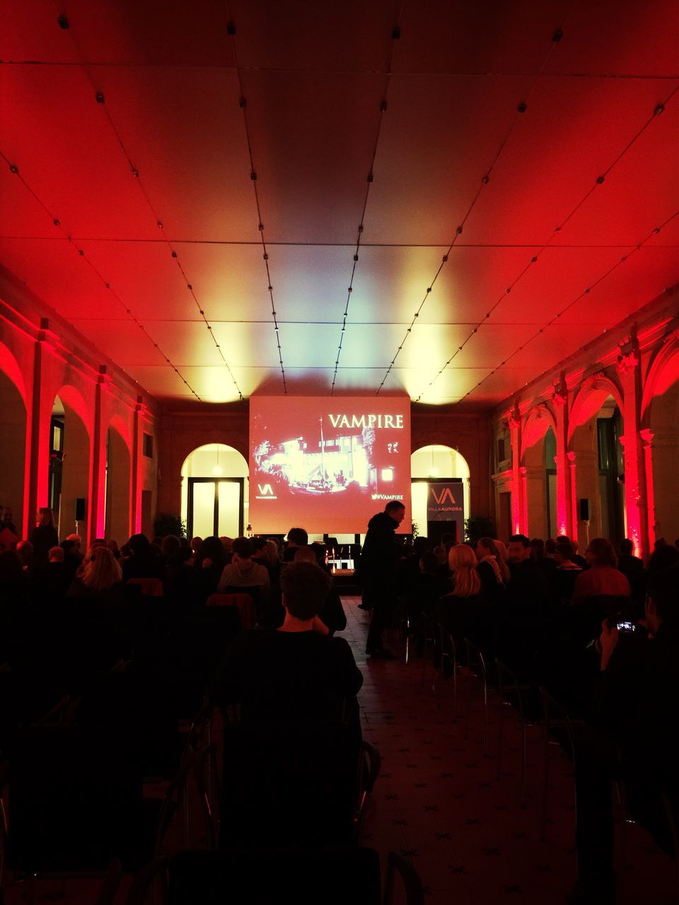 GROUP OF PEOPLE IN ILLUMINATED ROOM