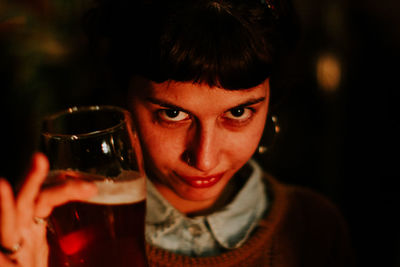 Close-up portrait of smiling woman holding drink