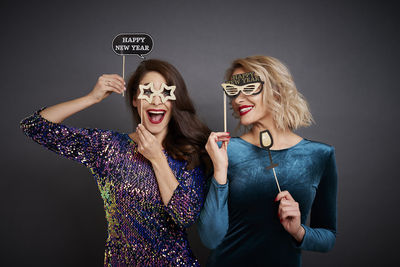 Young woman wearing mask against gray background