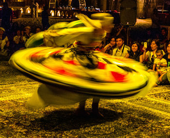 Group of people in amusement park at night