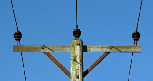 Low angle view of communications tower against clear blue sky