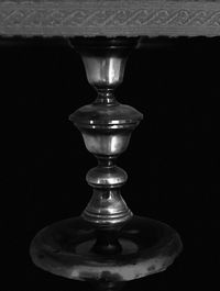 Close-up of wineglass on table against black background