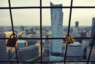 Close-up of railing against buildings in city