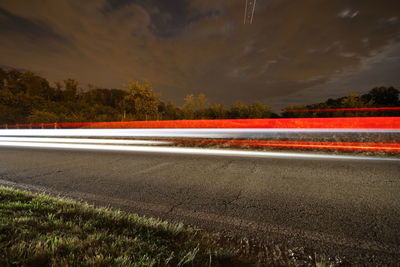 Light trails of a car on the road and an airplane in the sky