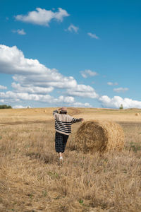 Hay bales on field against sky