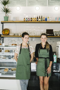 Smiling businesswomen standing by counter at coffee shop